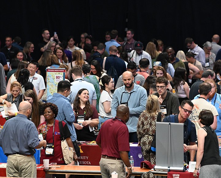 A large conference with people visiting tables