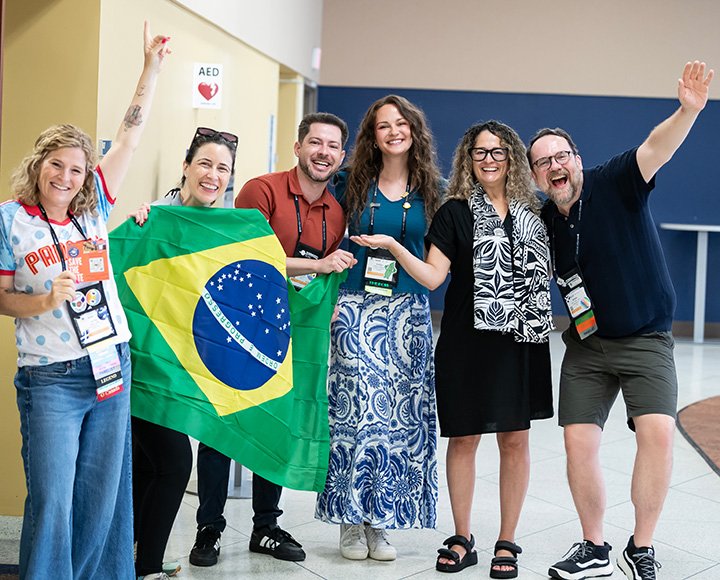 People smile and hold the Brazilian flag