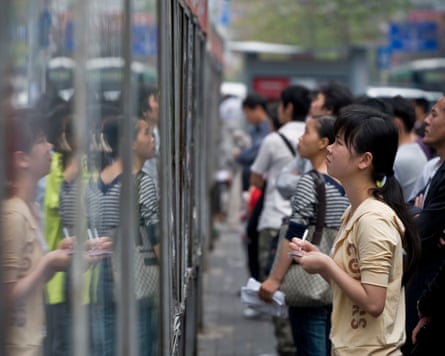 Job hunters check out adverts on a wall in Shenzhen