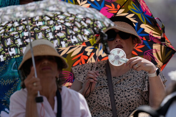 Faithful shelter from the hot sun as Pope Leo's XIV arrives for his weekly general audience in St. Peter's Square at The Vatican, Wednesday, June 24, 2026. (AP Photo/Alessandra Tarantino)