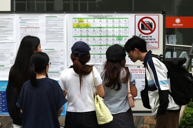 Test-takers check their assigned rooms at a 2025 Test of Proficiency in Korean (TOPIK) testing center at Dai Nam University in Hanoi. Korea Times file