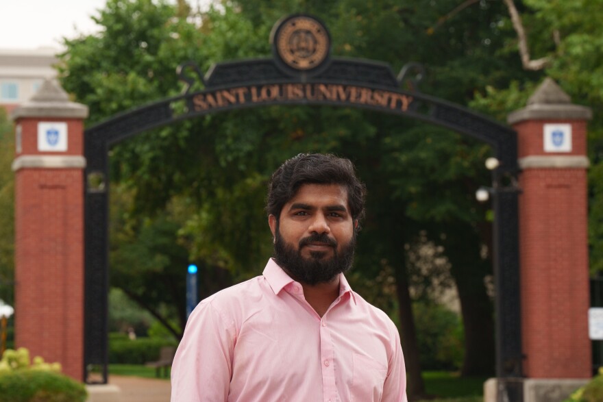Suman Subhash Naidu, who graduated from St. Louis University with a master’s degree May 2025, stands in front of a campus sign on Aug. 10, 2026. Naidu, a native of India, remains in the U.S. under the Optional Practical Training program, which allows students to work in the country for one year after graduation.