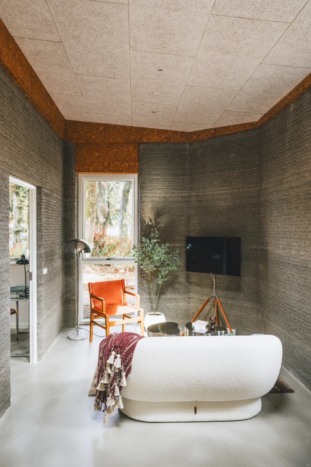 Wooden and cork detailing helps soften the concrete interiors of the 3D-printed Skovsporet apartments