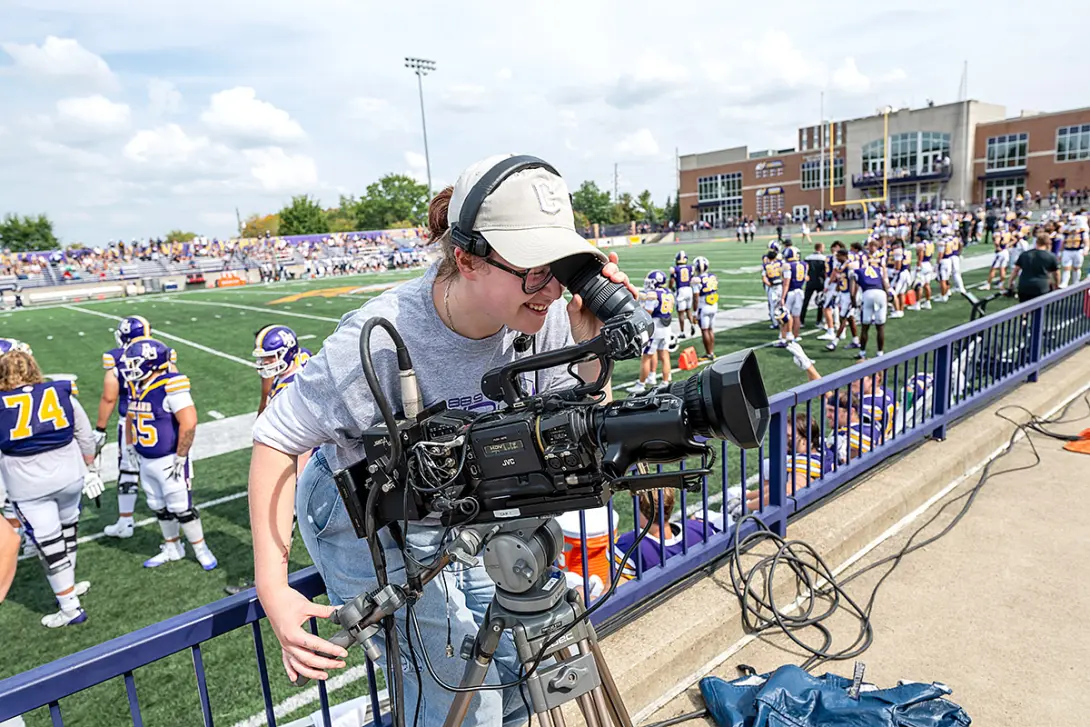 student videographer filming crowd at 2025 football game